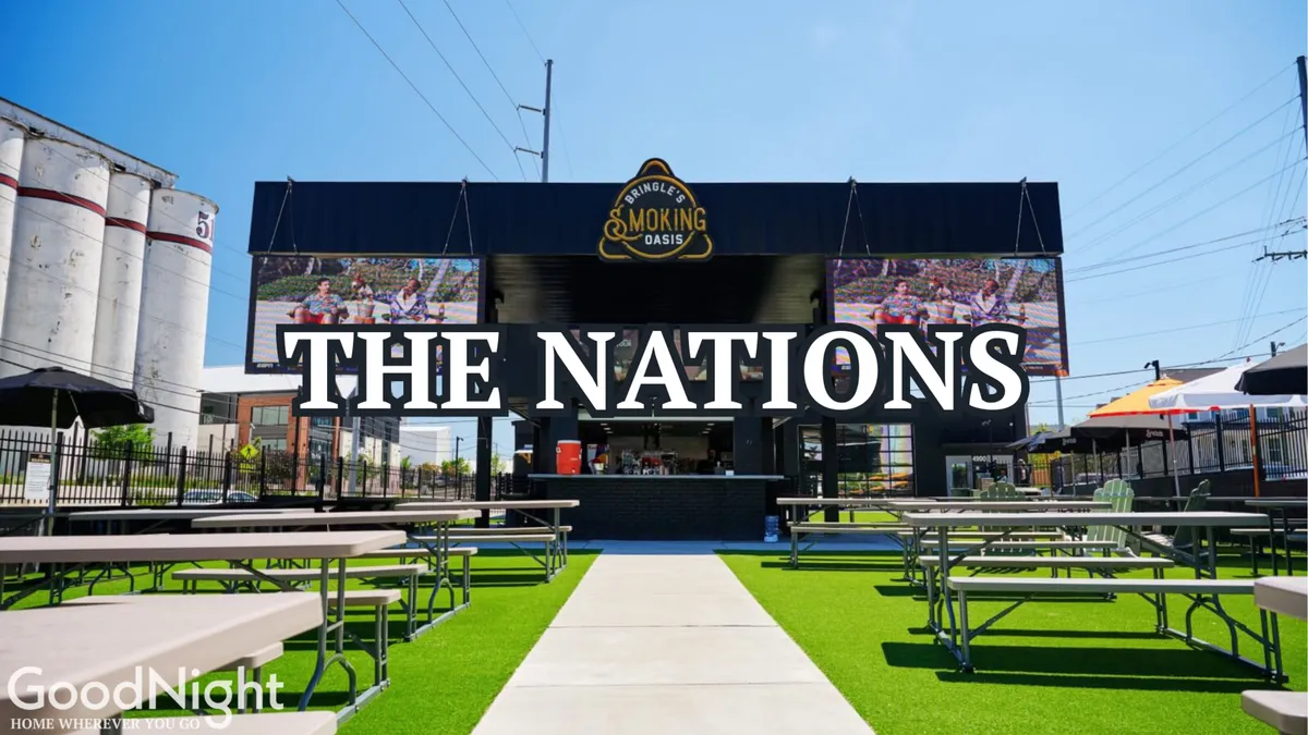 A dynamic exterior scene featuring 'THE NATIONS' main building, an outdoor seating area, and large screens displaying images. The lively atmosphere, with people gathered and engaged in activities, evokes the communal spirit of the neighborhood and the possibility of group exploration beyond the property itself.