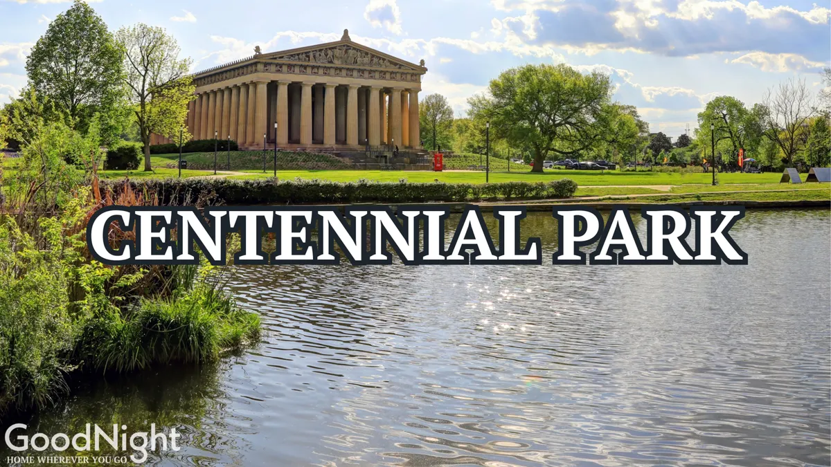 This image captures the serene water in Centennial Park with the iconic Parthenon replica in the background, surrounded by lush greenery. The scene is peaceful and welcoming, with ample space for picnics and family activities near the lake.