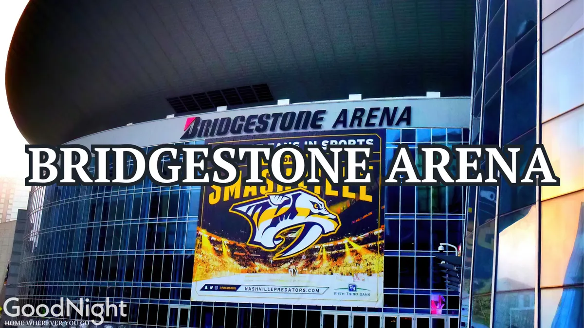 A dramatic exterior shot of Bridgestone Arena, with its prominent signage and Nashville Predators banner, showcasing the glass facade and energetic street activity nearby. The arena is set as a landmark for major concerts and sporting events.